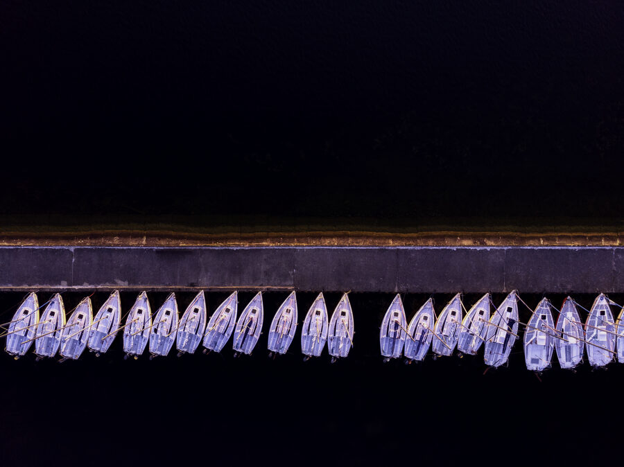 Aerial view of moored boats along a quay at night