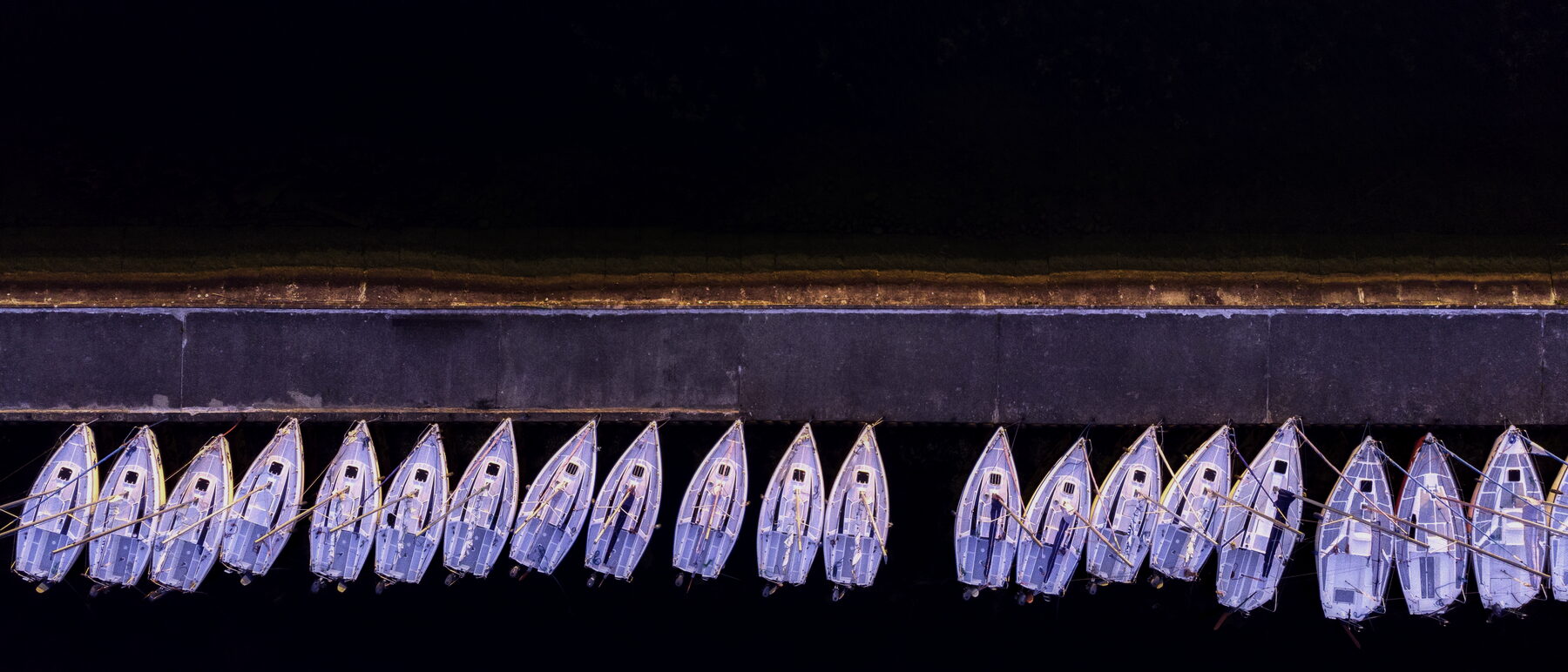 Aerial view of moored boats along a quay at night